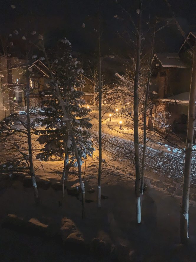 cozy bedroom window view of a snow lined street with winter villas