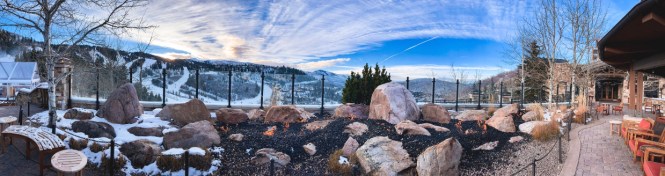 expansive view from mountaintop at st. regis deer valley utah bar overlooking mountainsides and the sky with a fire pit and beautiful lights